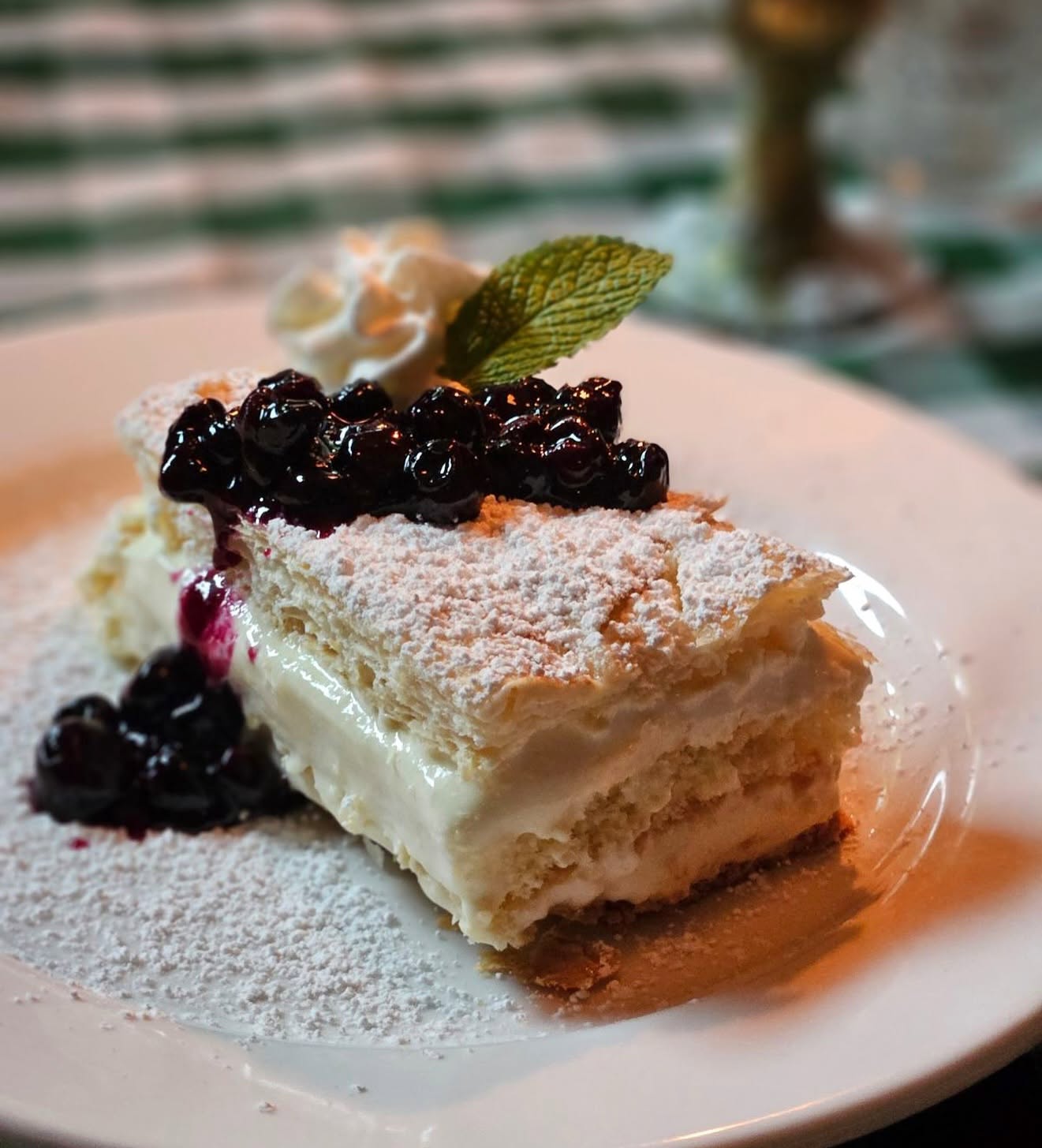 A layered cake with blueberry compote and powdered sugar