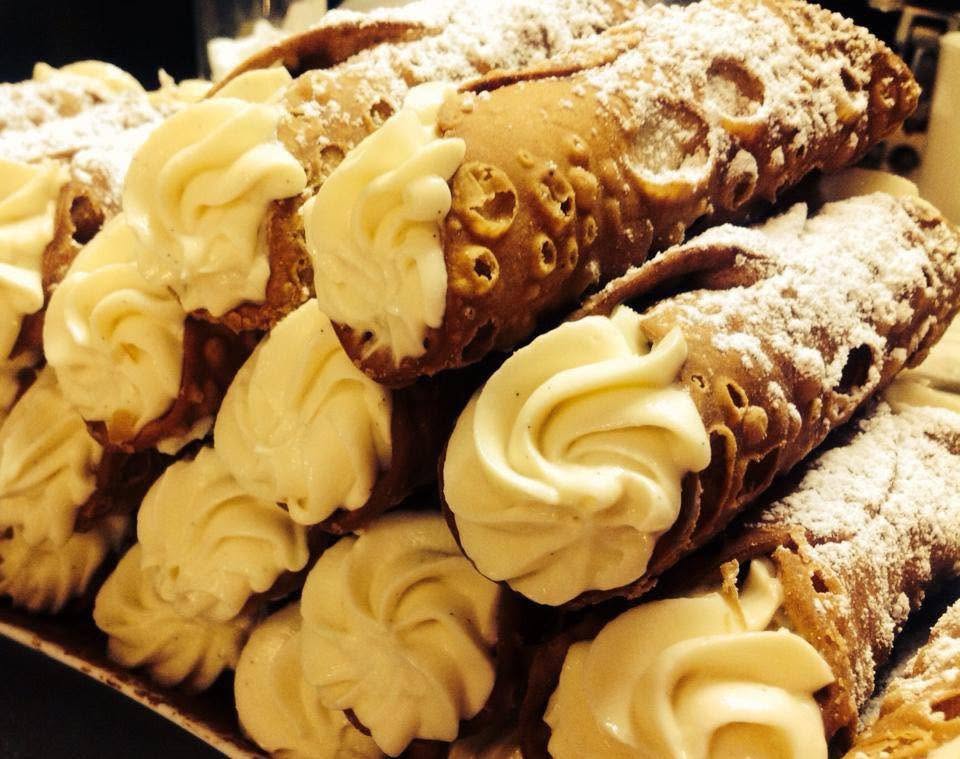 A platter of cannoli piped with cream