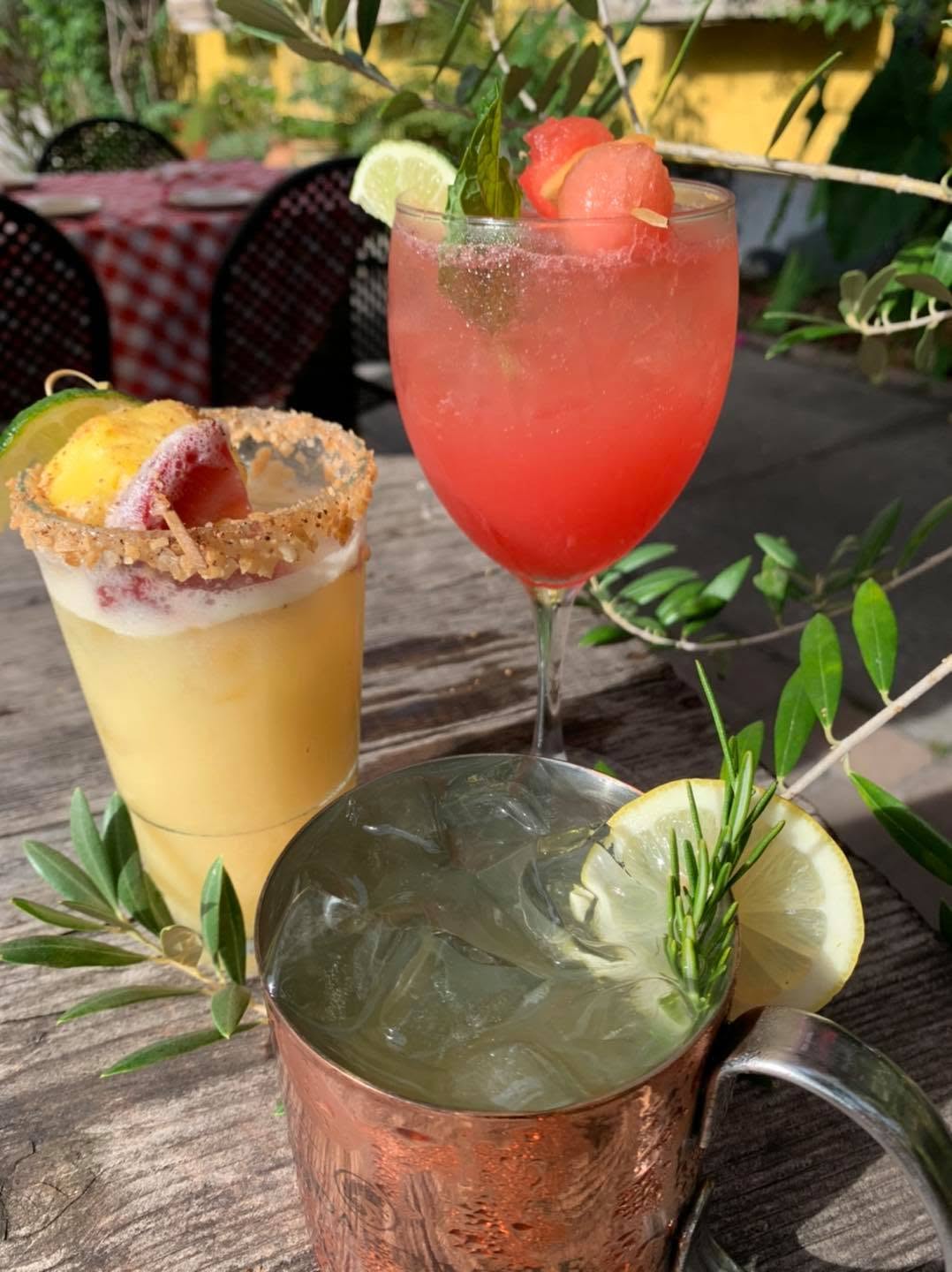Three cocktails including a copper mule on an outdoor table