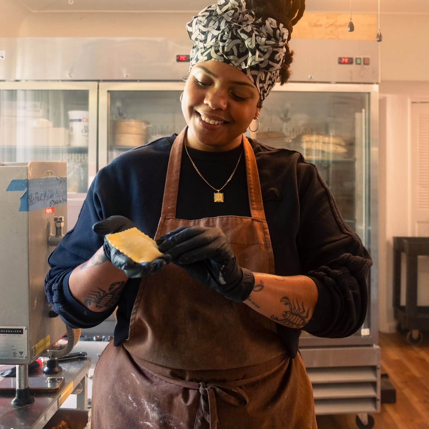 A cook at the Trattoria smiling as she shapes fresh dough