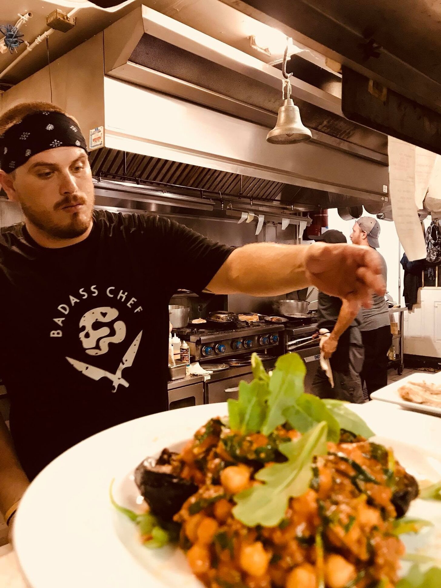 A cook finishing a plate in the Trattoria kitchen