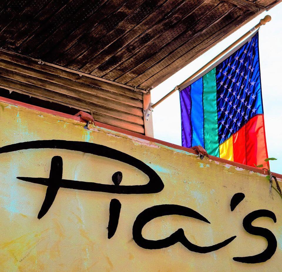 The brush-script Pia's sign painted on the yellow stucco wall
