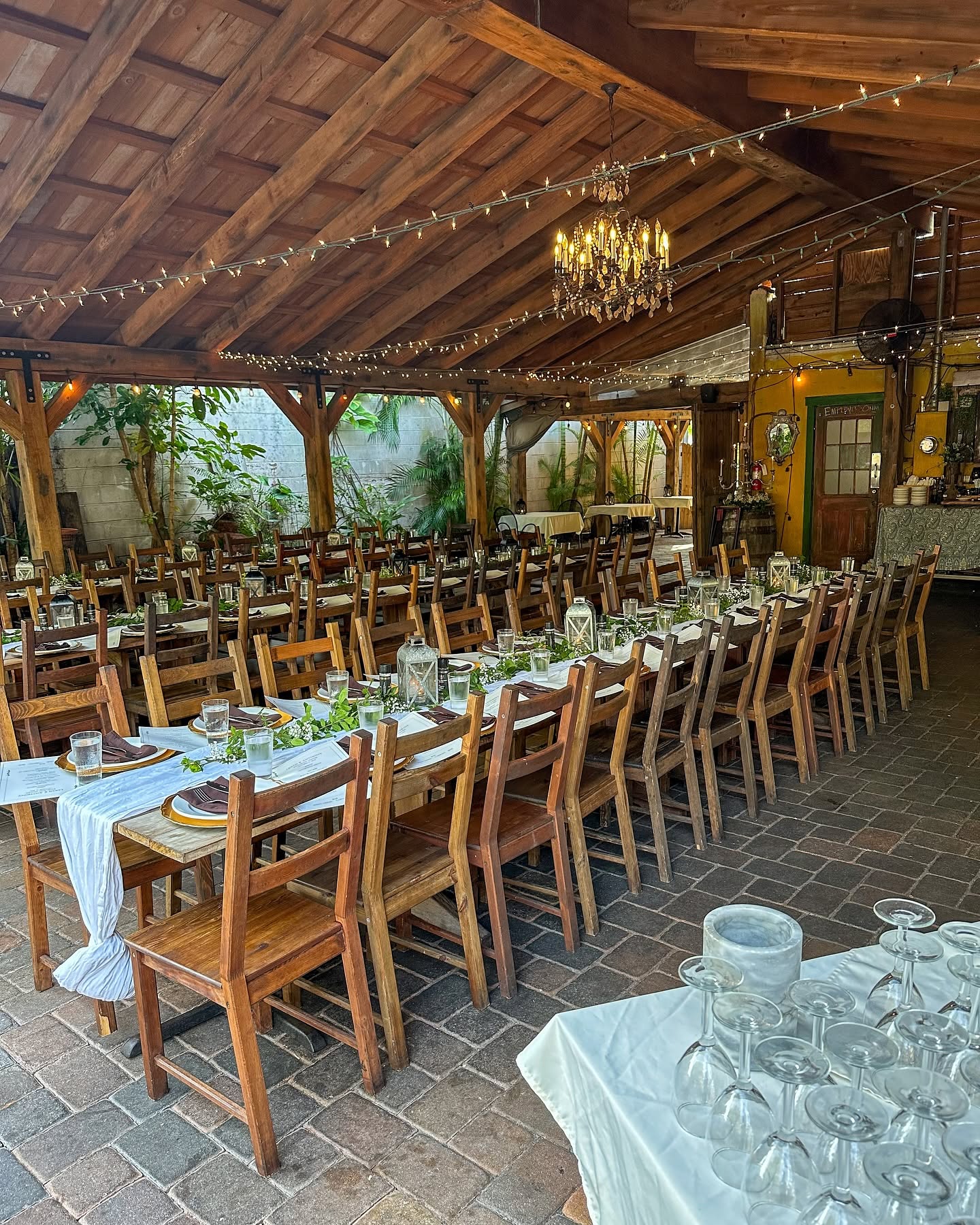 Long wooden tables with runners on the covered patio