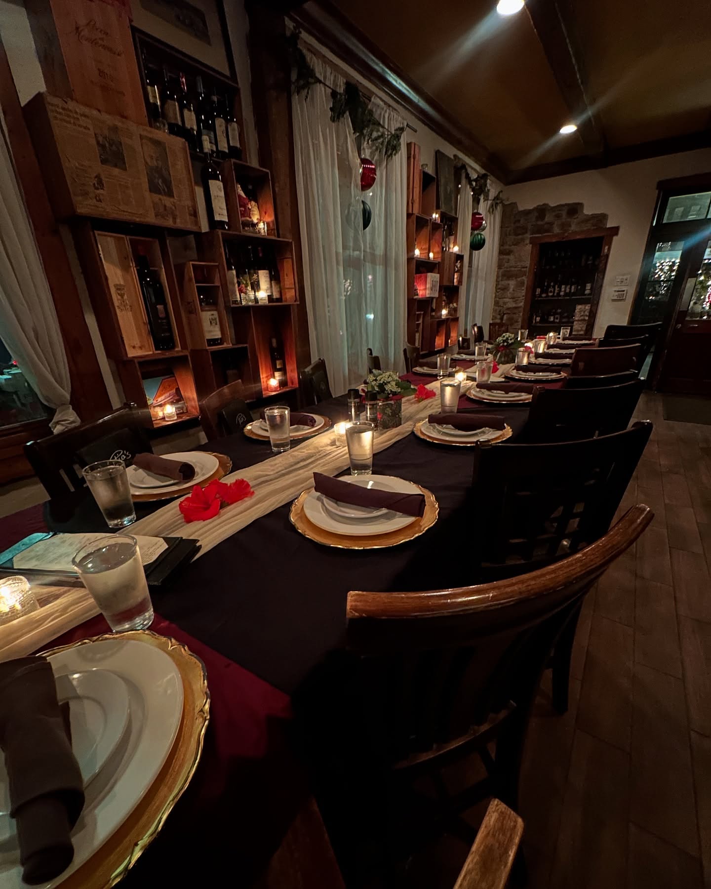 Candles and gold chargers down the wine-rack room's table