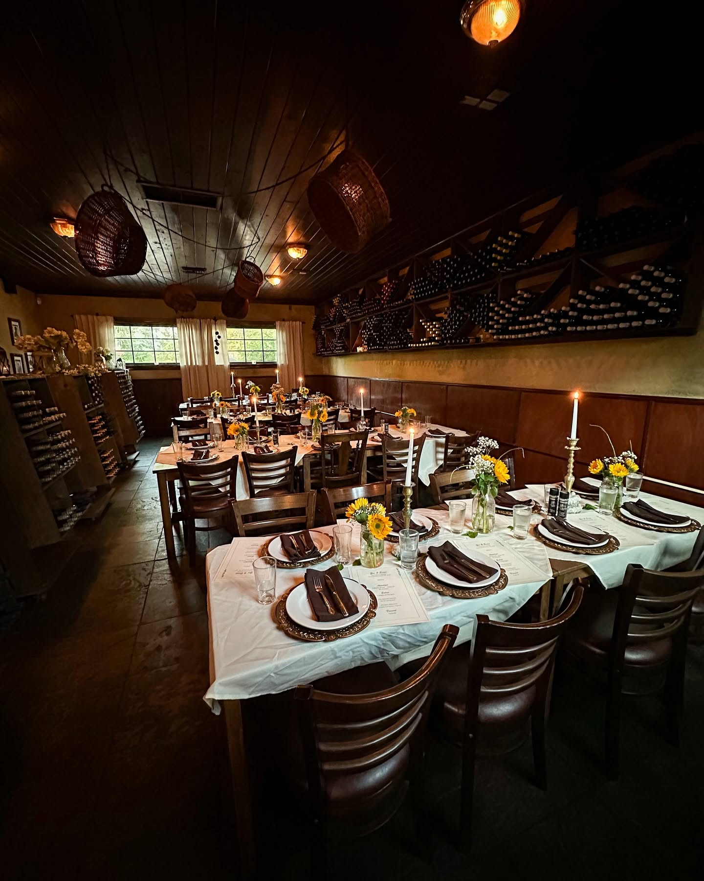 The wine-rack room set for a long dinner with sunflowers