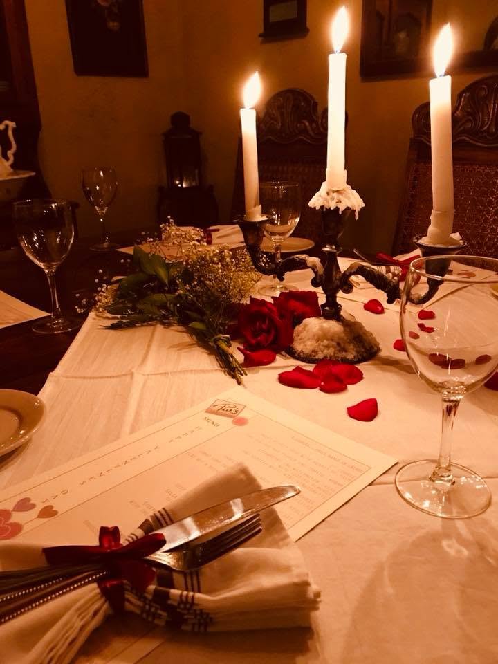 Candles and rose petals on a white tablecloth