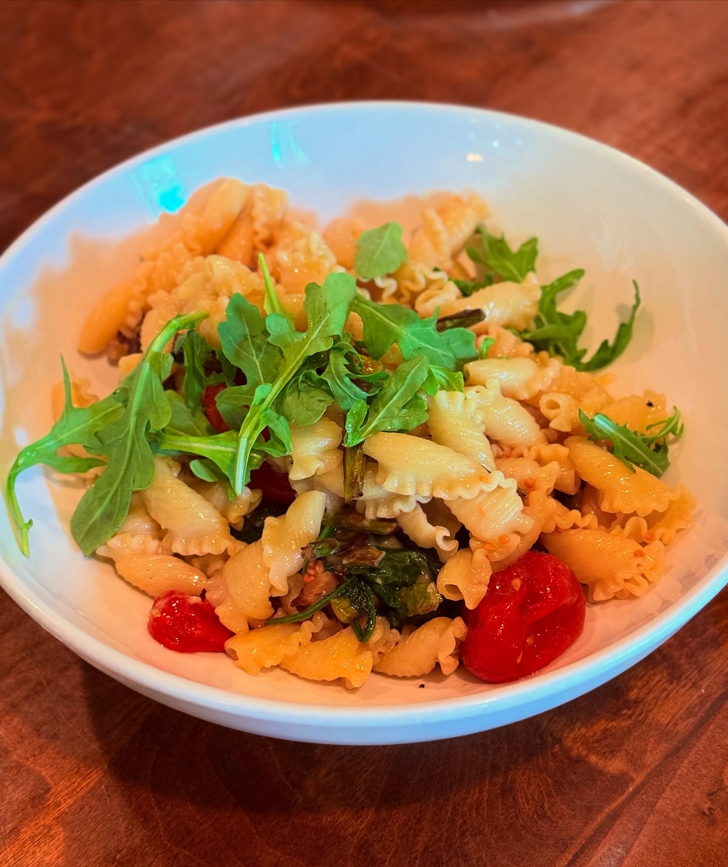 Cavatelli with arugula, pesto and roasted tomatoes, on the Trattoria's dark wood table