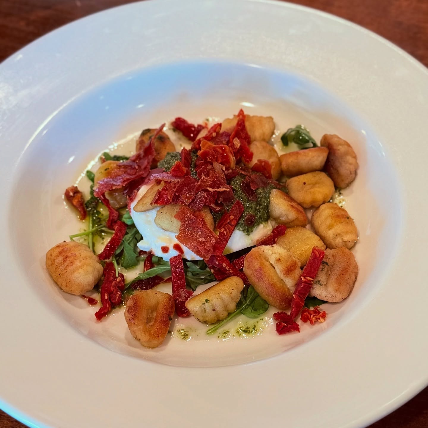 Gnocchi with sun-dried tomatoes and herbs, on the Trattoria's dark wood table